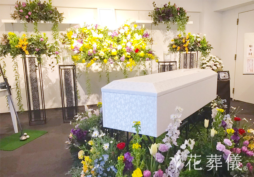 花祭壇の写真 チューリップ、菜の花、オランジュームなど華やかで彩り豊かな花々をメインにポイントで紫のお花をお入れし、力強い印象の花祭壇