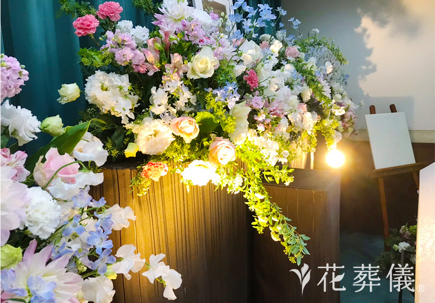 花の祭壇 白ピンクをベースに淡いブルーや濃いピンクのバラをポイントで入れ、コントラストをお付けした祭壇