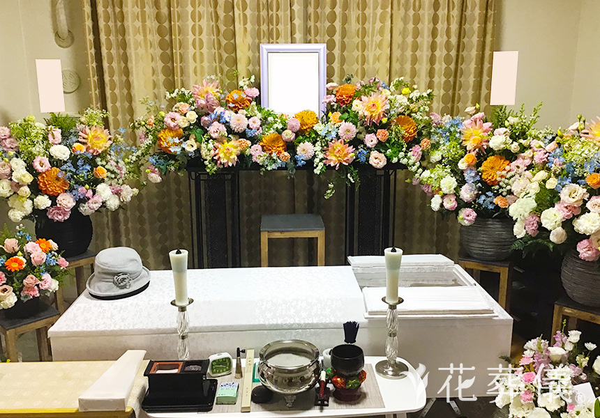 花祭壇の写真 白ピンクベースにあわい水色やオレンジなどを入れて、かわいい感じの空間をイメージして
