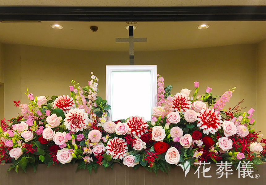 花祭壇の写真 ダリア、バラなどの華やかな花をお入れし、お好きだった赤、ピンクのお色味でシンプルでありながら、存在感のある空間をイメージして