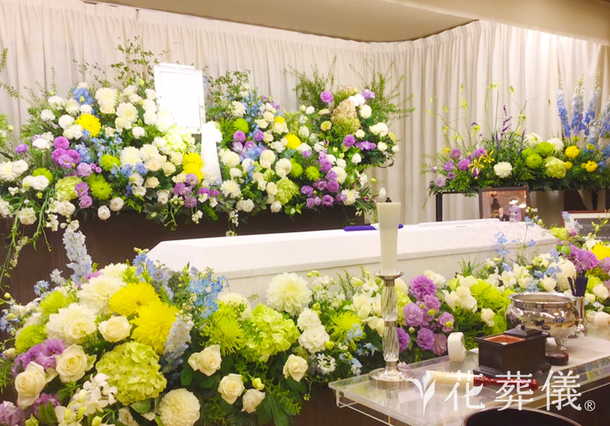 花の祭壇 大きくしたお写真を祭壇両サイドにお飾りし、白、グリーン、ラベンダー、ポイントで水色、黄色で仕上げた祭壇