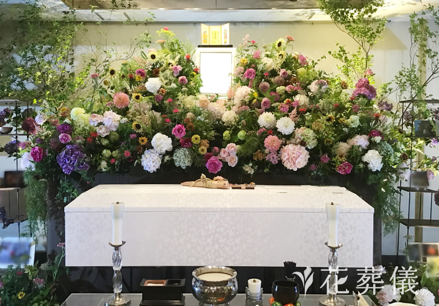 花祭壇の写真　ご旅行で行かれた島のジオラマと思い出のお写真をお飾りし、奥様がお好きだったガーベラをメインに淡いお色味でまとめた祭壇