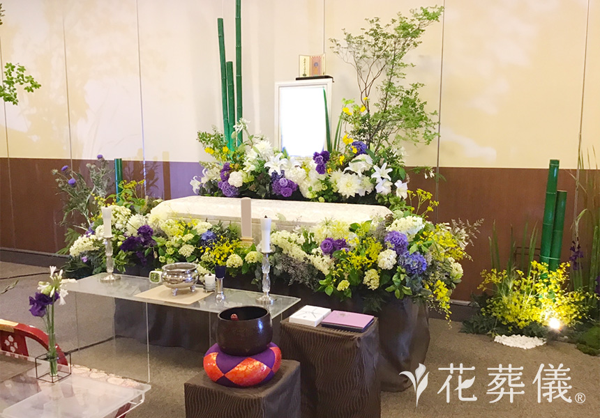 花祭壇のデザイン 全体的にホワイトとグリーンでまとめ、ポイントにパープル、イエローを添え、苔や竹を用いて山寺のような空間をイメージして