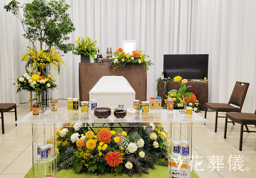 花祭壇の写真 お父様がお好きだったお酒と一緒にイエローやオレンジで暖かい太陽の光をイメージした空間