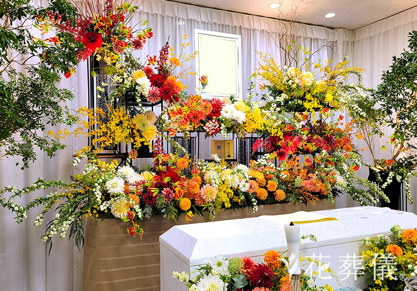花祭壇のデザイン 赤やオレンジや黄色や白のダリアを中心に、華やかであたたかい空間をイメージして
