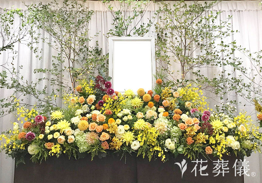 花祭壇の写真　お花がお好きだったお母様のためにつくったイエローやオレンジ色のお花がいっぱいの、元気で明るい空間をイメージ