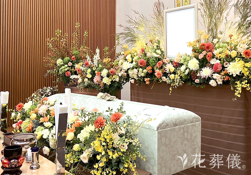 花葬儀の花祭壇　グリーンがお好きで明るく働き者だったお母様をイメージして。明るい印象のオレンジやグリーンをたくさん使用した花祭壇