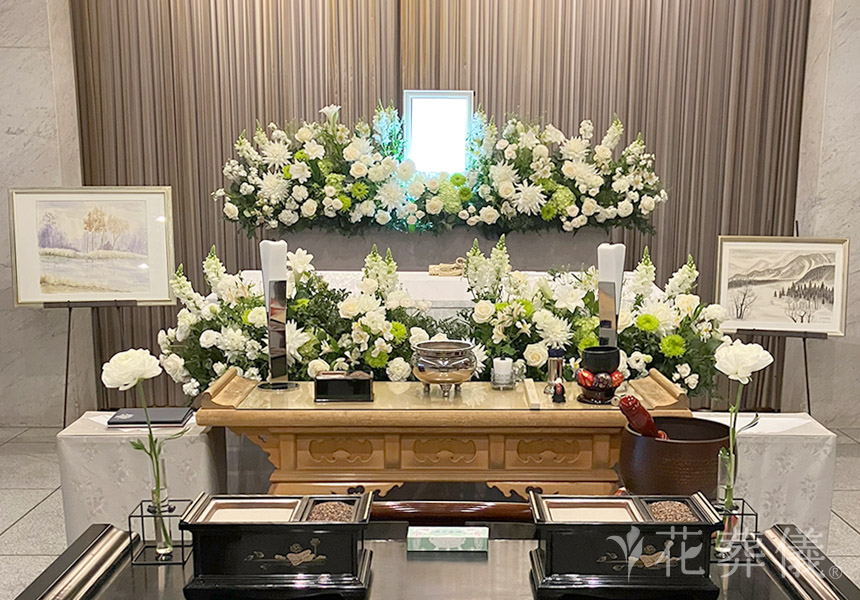 花祭壇の写真　白と緑のお花を基調にお飾りし、作品展の空間をイメージした世界でたったひとつの花祭壇