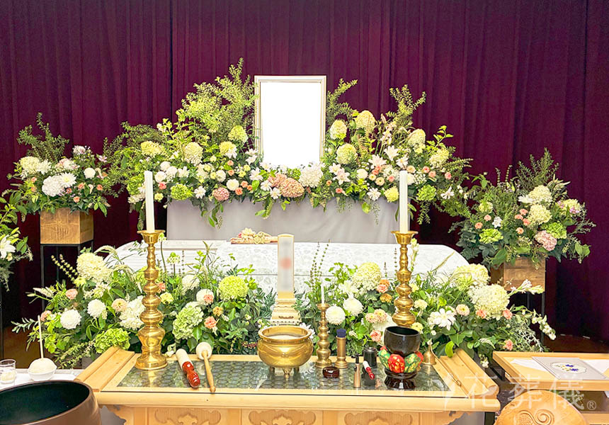 花祭壇の写真　自然な白を基調とした中に、女性らしさの淡いピンクのお花をお飾りした花祭壇