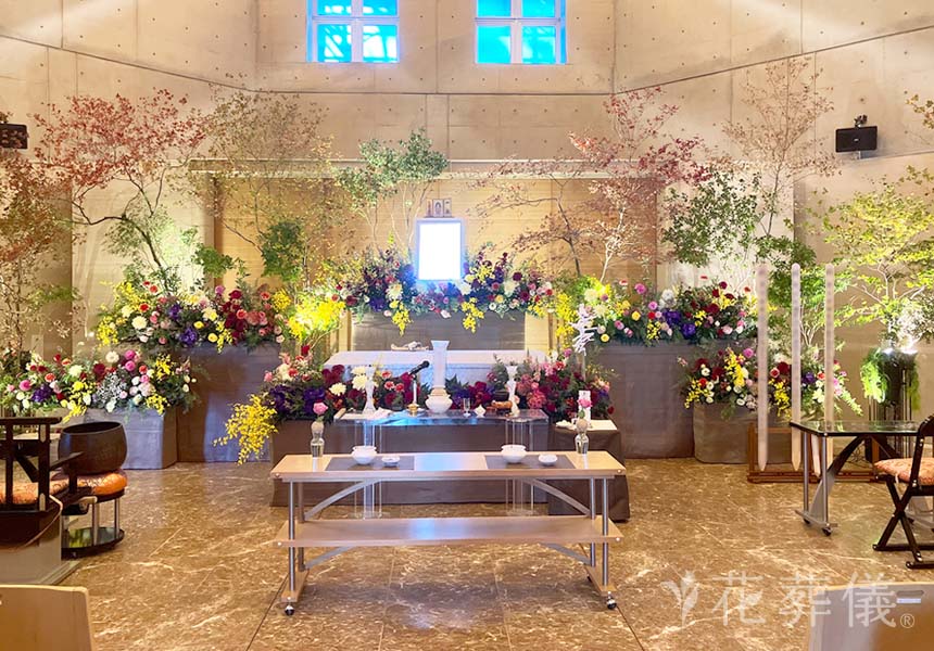 コーポレートカラーの紫と、好きな色であるショッキングピンクと赤のお花で、悲しいより楽しい雰囲気でお疲れ様！の華やかな空間をイメージして