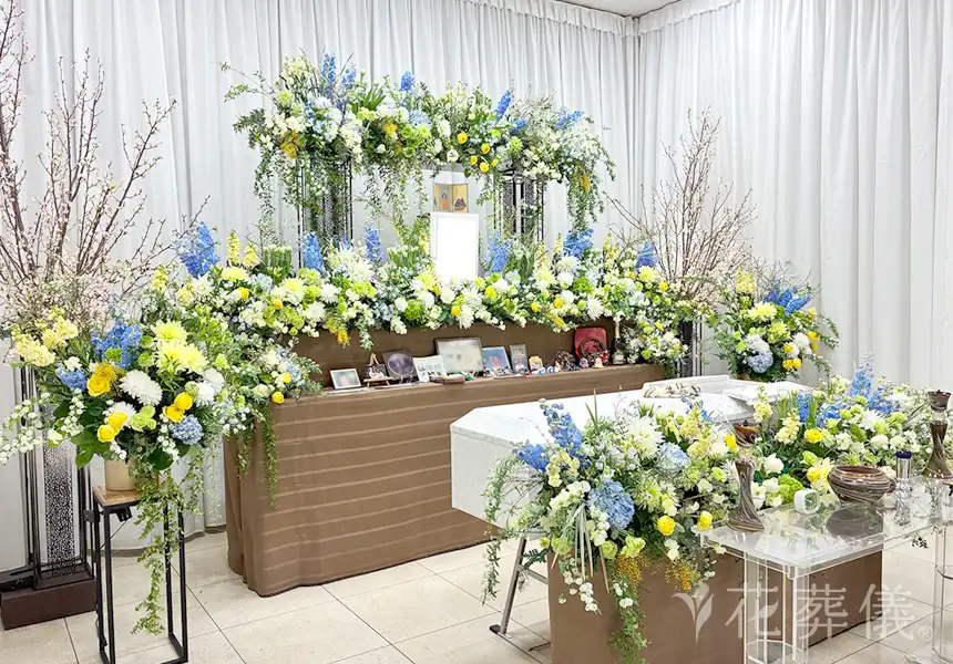 花葬儀の花祭壇　アクティブなお人柄をブルーのお花で、春のお花いっぱいに、ふなっしー色と白グリーン系のお花でおまとめした花祭壇