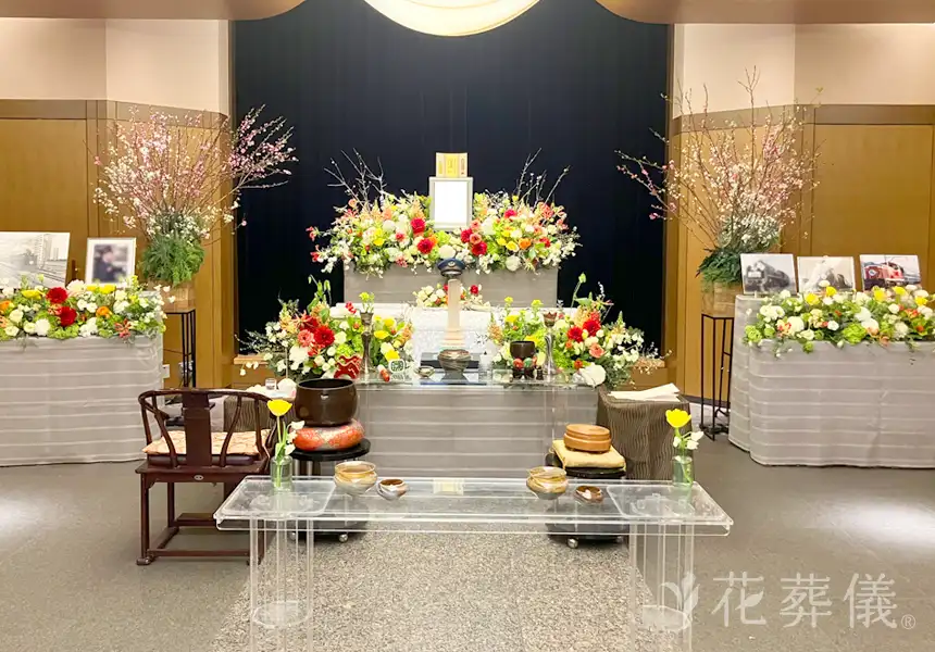 桃の花と、お誕生月のアジサイ、活動的なイメージに合わせた赤やオレンジ、黄色をメインにした花祭壇