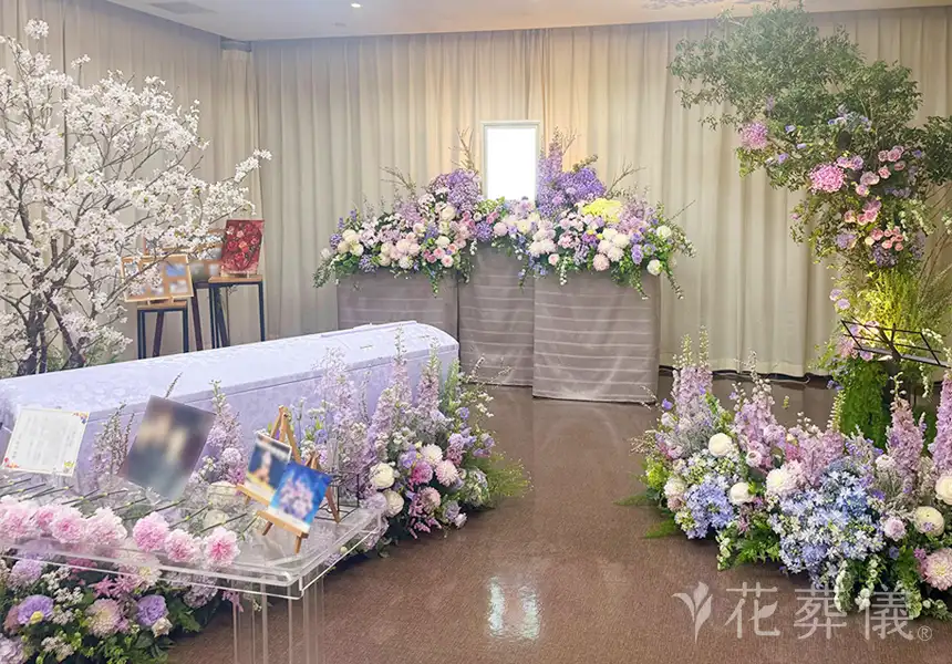 花祭壇のデザイン　花びらの多いダリアやサジサイ、ラナンキュラスなどをお入れし、ご自身で制作した陶芸や切り絵などの作品となじむ淡いお色のピンクや紫の花でお飾りした祭壇