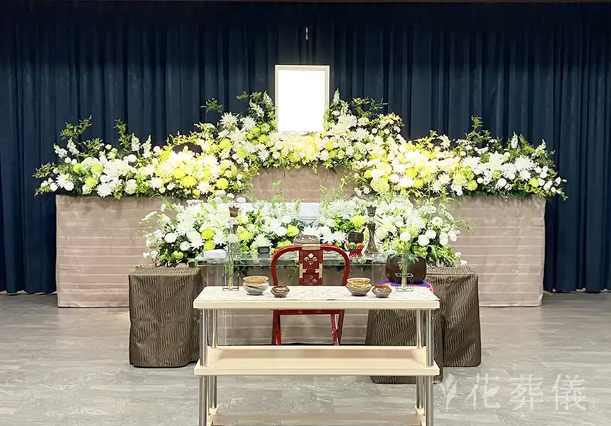 花祭壇の写真　ご家族よりお疲れ様の気持ちを込めて、新緑の季節らしく爽やかなグリーンを沢山いれて風そよぐ空間をイメージして