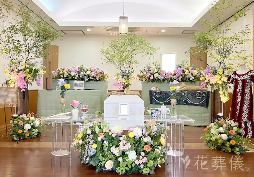 花祭壇の写真　淡いピンクや黄色、オレンジなどのお花でグラデーションをかけ、音楽を流しながら優しく明るい空間をイメージして