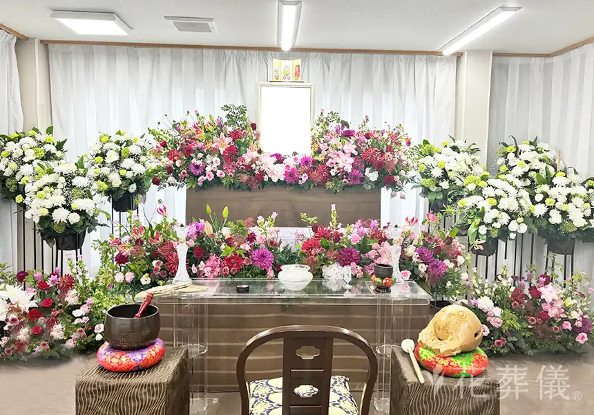 花葬儀の花祭壇　祭壇を埋め尽くす鮮やかな赤、濃いピンク、そして紫の花々は、心の中に燃やし続けた情熱の灯火をイメージした世界でたったひとつの花祭壇